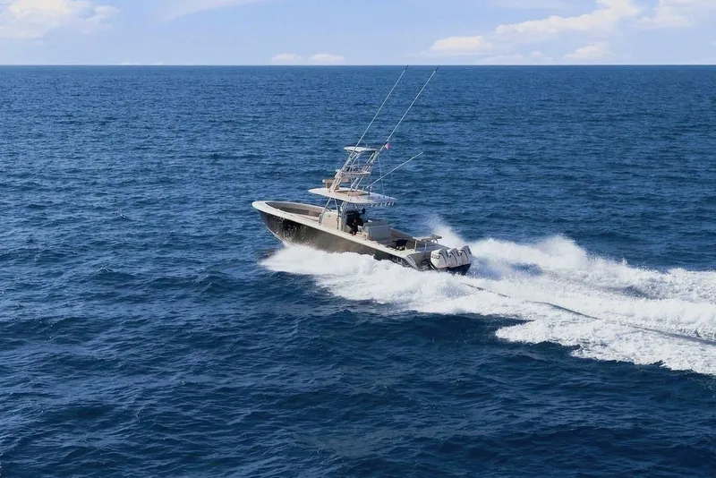 Slide: The Image of A 2013 Bahama 41 boat speeds across open sea, featuring two fishing rods. - 7