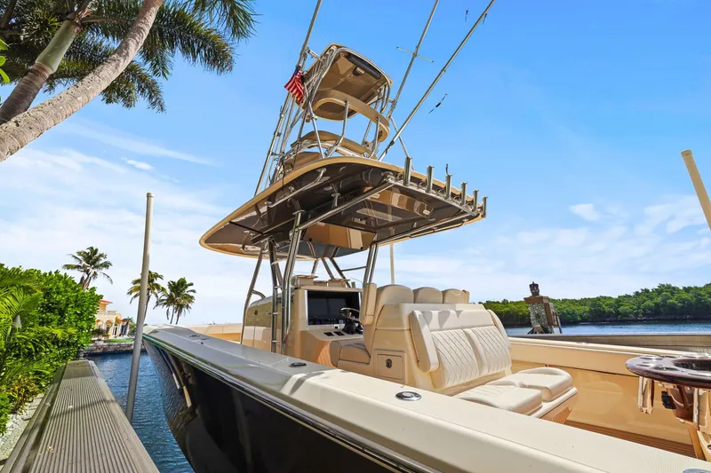 Slide: The Image of 2013 Bahama 41 boat docked by tropical waterfront with palm trees and clear blue sky. - 18