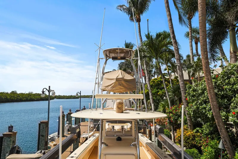 Slide: The Image of 2013 Bahama 41 boat docked by tropical palm trees and calm water. - 39