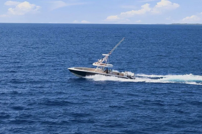 Slide: The Image of A 2013 Bahama 41 boat speeds across the open sea under a clear sky. - 6
