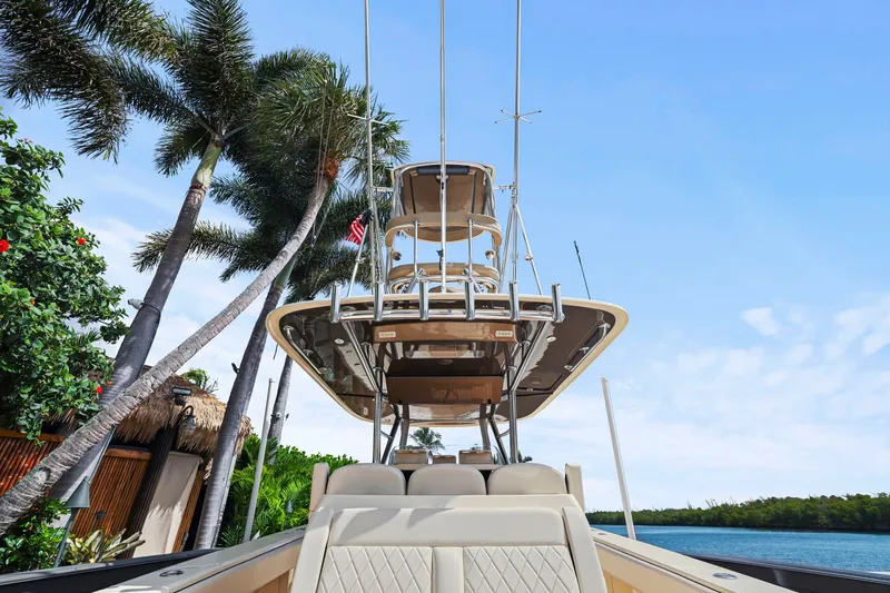 Slide: The Image of 2013 Bahama 41 boat with tower, docked near palm trees and blue sky. - 37