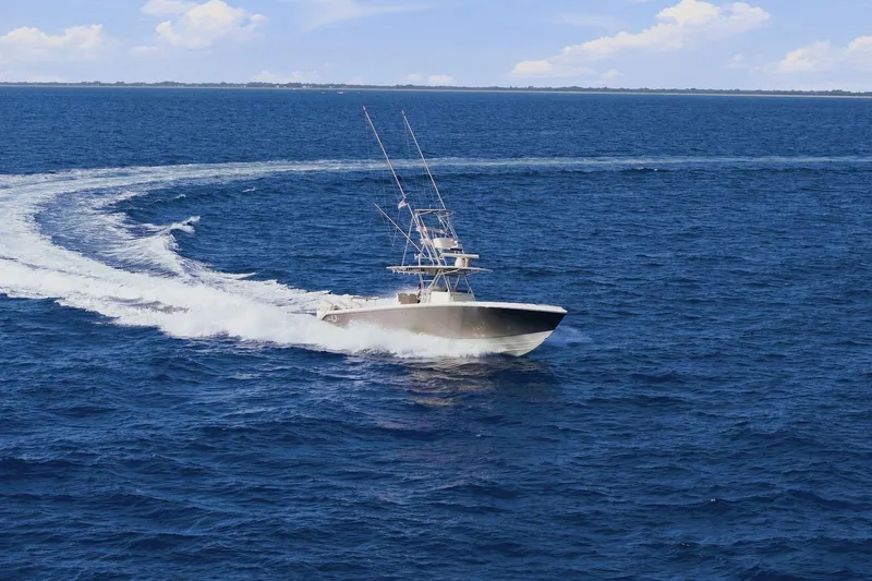 Slide: The Image of 2013 Bahama 41 boat cruising on open ocean with wake trail. - 2