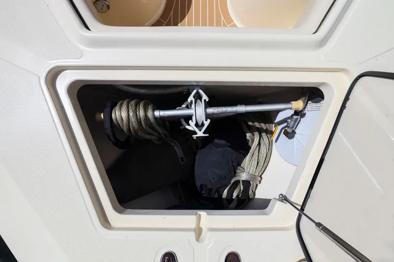 Slide: The Image of A storage compartment on a boat with an anchor, ropes, and fenders. - 13