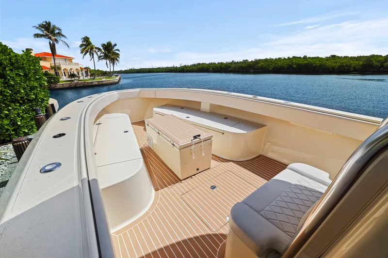 Slide: The Image of 2013 Bahama 41 boat with spacious deck, scenic waterfront view, and luxurious seating. - 14