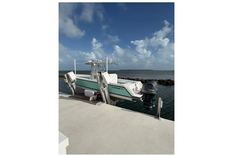 Slide: The Image of 2014 Contender 32 ST boat docked by the ocean under a cloudy sky. - 10