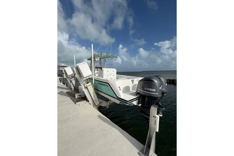 Slide: The Image of 2014 Contender 32 ST boat docked with Yamaha outboard motor, under a partly cloudy sky. - 6