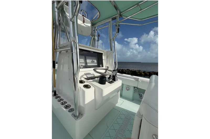 Slide: The Image of 2014 Contender 32 ST boat cockpit with steering wheel and navigation screens, ocean view. - 8