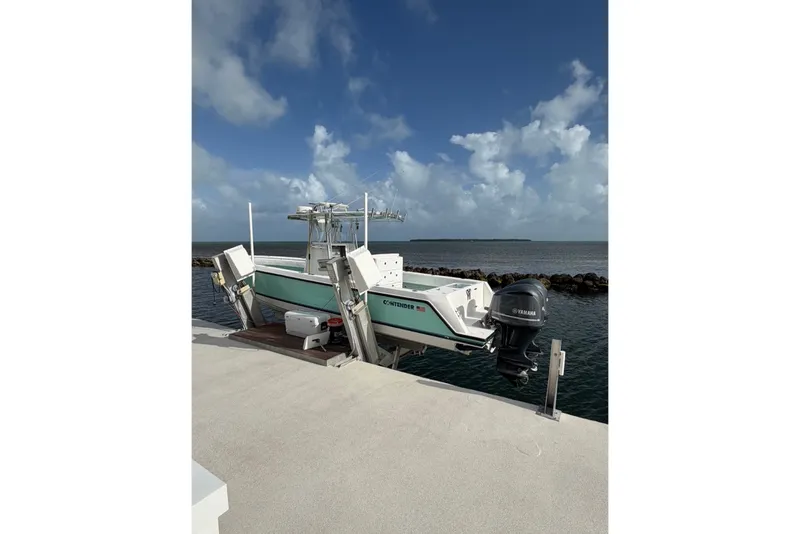 Slide: The Image of 2014 Contender 32 ST boat docked by the ocean under a cloudy sky. - 1