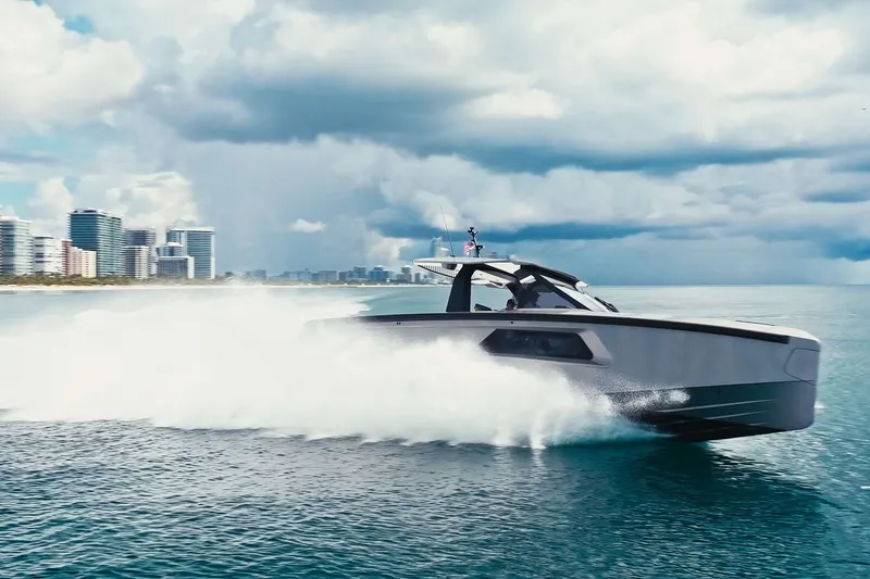 Slide: The Image of 2024 Maori 46ft yacht speeding on ocean near city skyline under cloudy sky. - 14
