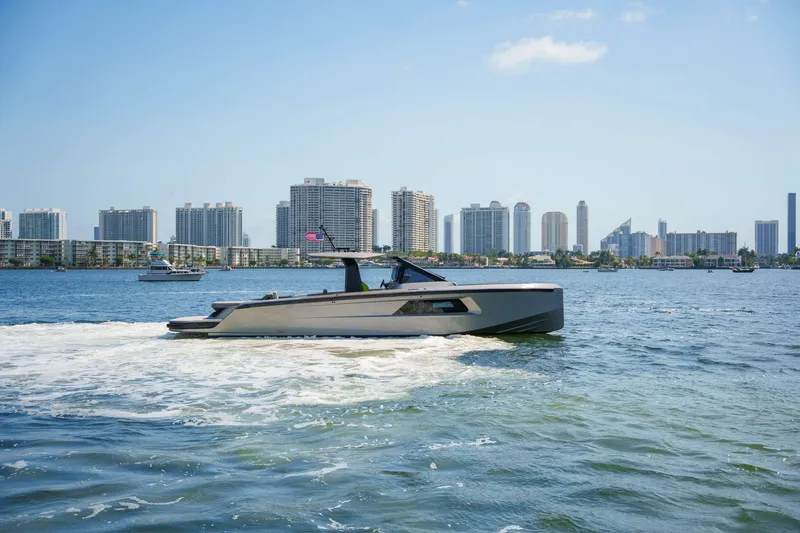 Slide: The Image of 2024 Maori 46ft yacht cruising on a sunny day with city skyline backdrop. - 44