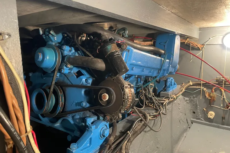 Slide: The Image of Engine compartment of a 1974 Chris-Craft 350 Catalina boat, showcasing blue machinery and wiring. - 10