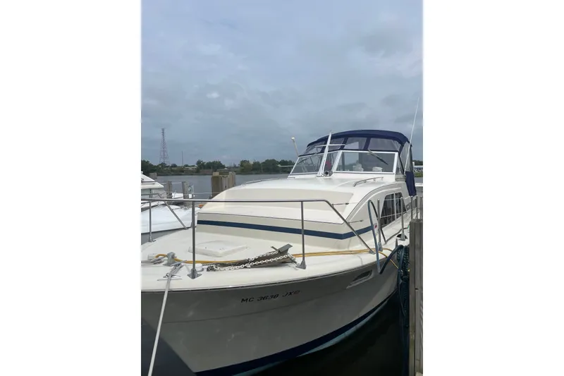 Slide: The Image of 1974 Chris-Craft 350 Catalina boat docked, featuring a blue canopy and white hull. - 1