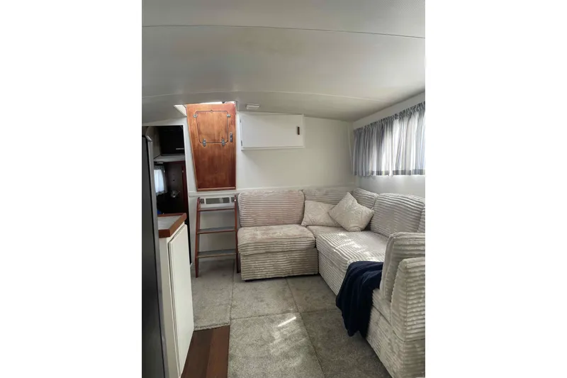 Slide: The Image of 1974 Chris-Craft 350 Catalina interior with cozy seating and wooden accents. - 5