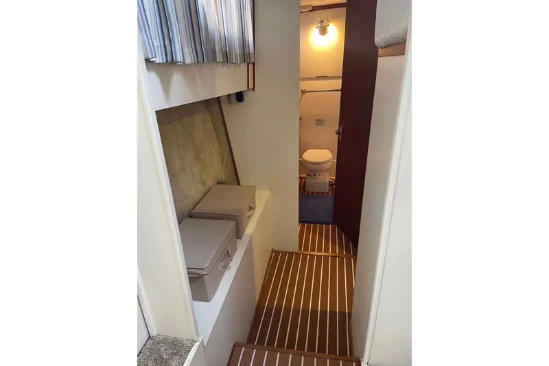 Slide: The Image of 1974 Chris-Craft 350 Catalina interior with wooden flooring and compact bathroom. - 8
