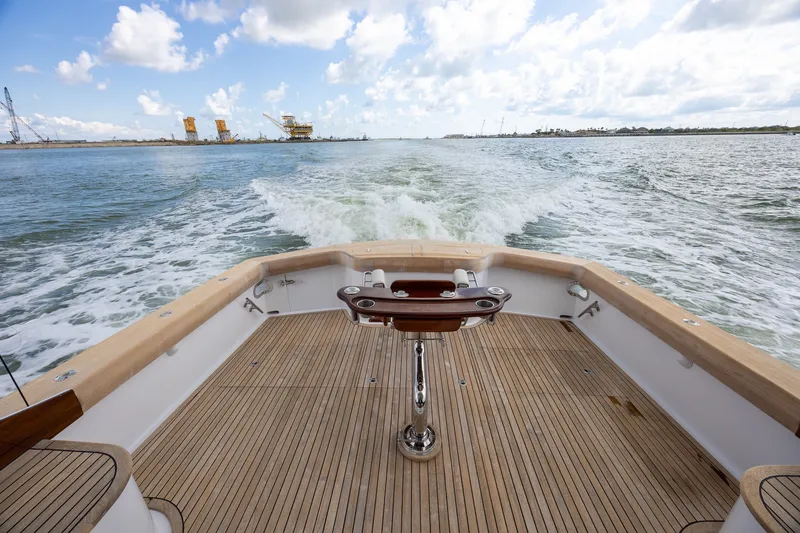 Slide: The Image of Rear view of 2008 B&D Convertible boat cruising on open water, showcasing wooden deck. - 20