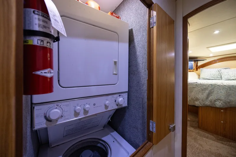 Slide: The Image of Compact laundry area in a 2008 B&D Convertible boat, featuring a washer-dryer unit. - 42