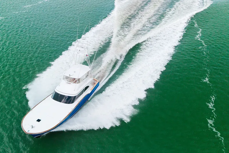 Slide: The Image of Aerial view of 2008 B&D Convertible yacht cruising on vibrant green water. - 2