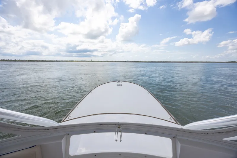 Slide: The Image of Bow view from a 2008 B&D Convertible boat on open water under a cloudy sky. - 12