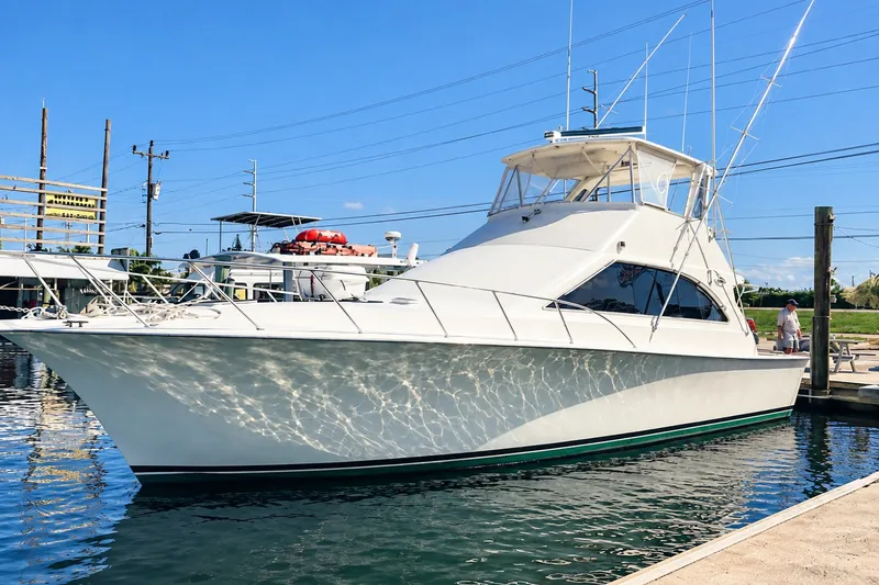 The Image of 1995 Ocean Yachts 48 Super Sport docked at marina under clear blue sky. - 0