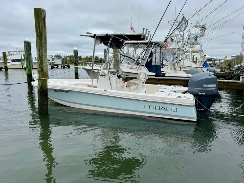 Slide: The Image of A 2015 Robalo 206 Cayman boat is docked in the water. It features an outboard motor. - 1