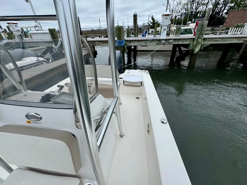 Slide: The Image of A 2015 Robalo 206 Cayman is docked. It features a clean, white surface. - 12