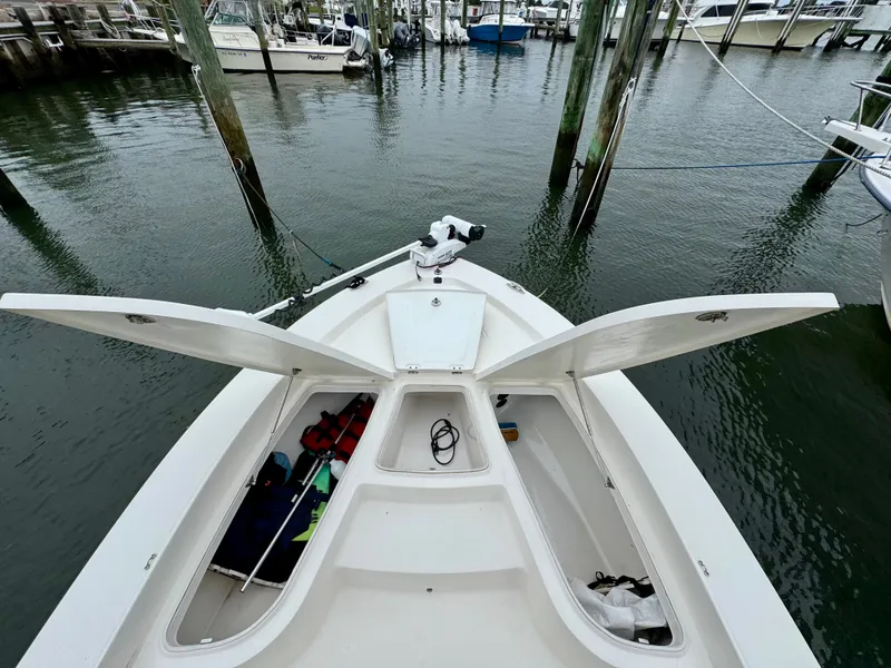 Slide: The Image of The image shows the bow of a 2015 Robalo 206 Cayman boat with open storage compartments. - 16