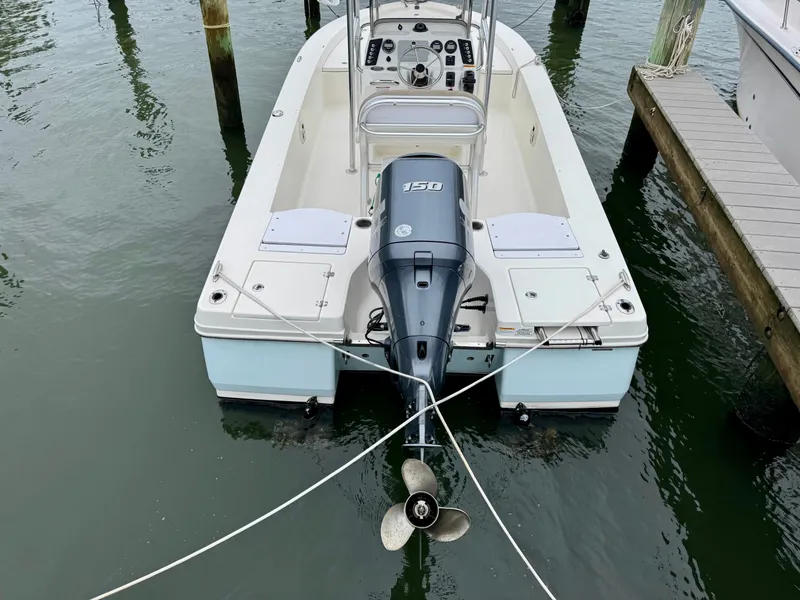 Slide: The Image of A 2015 Robalo 206 Cayman boat docked. It features a 150 HP outboard motor. - 3