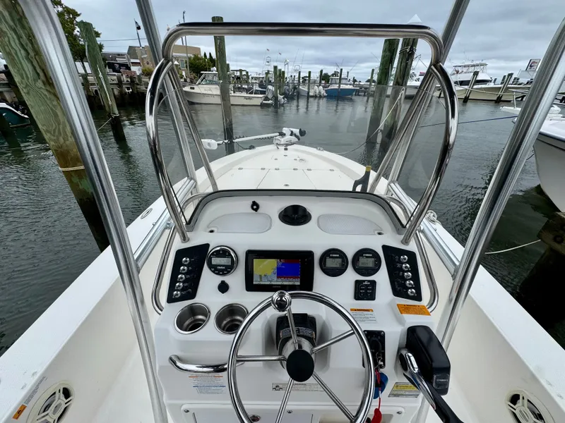 Slide: The Image of The image shows the helm of a 2015 Robalo 206 Cayman boat docked at a marina. - 4