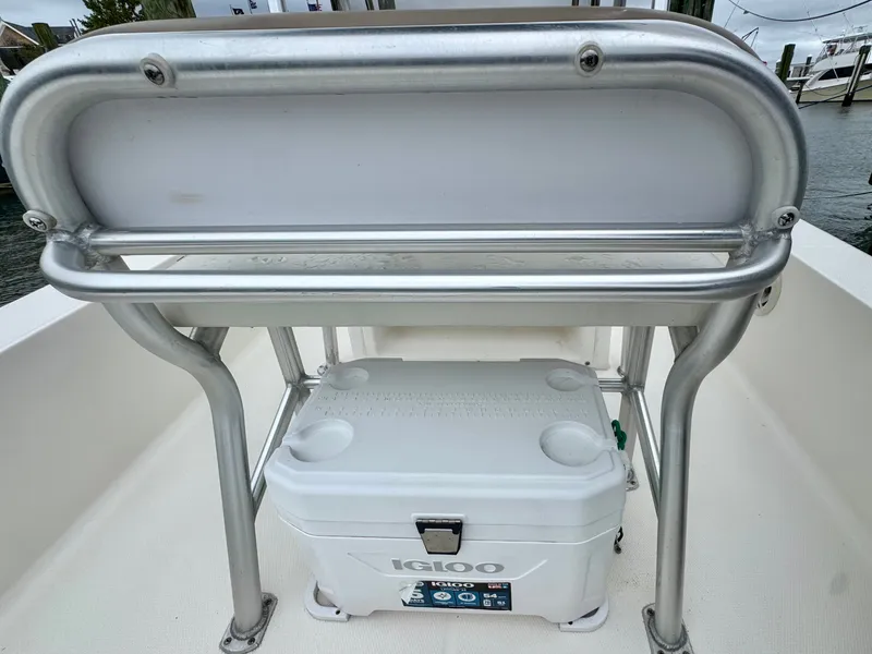 Slide: The Image of A white Igloo cooler under a silver bench seat on a boat. - 14