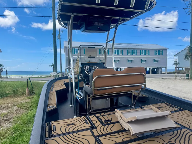 Slide: The Image of A 2026 Xpress H22 boat with a sleek design, positioned on a trailer in a coastal setting. - 3