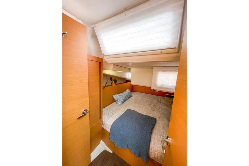 Slide: The Image of Cozy cabin interior of 2023 Jeanneau Sun Odyssey 440 sailboat with bed and wooden finish. - 15