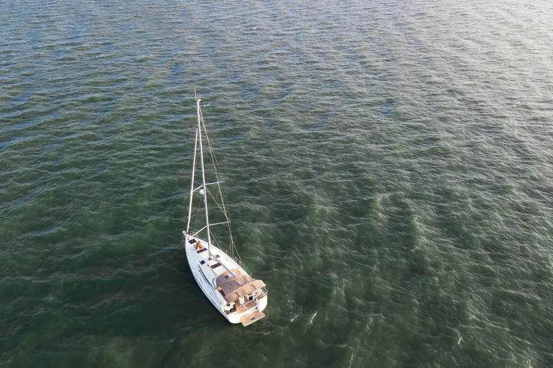 Slide: The Image of Aerial view of 2023 Jeanneau Sun Odyssey 440 sailing on open water. - 23