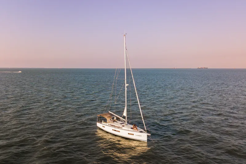 Slide: The Image of 2023 Jeanneau Sun Odyssey 440 sailing on open sea at sunset. - 5