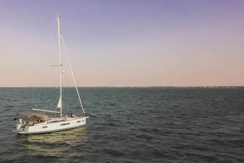 Slide: The Image of 2023 Jeanneau Sun Odyssey 440 sailing on calm waters at sunset. - 22