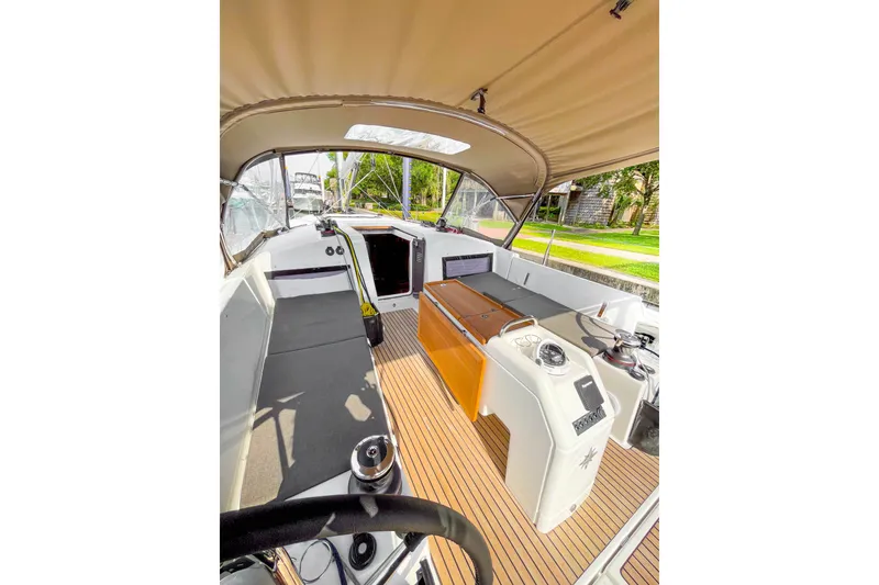 Slide: The Image of 2023 Jeanneau Sun Odyssey 440 cockpit with canopy, featuring modern navigation equipment and seating. - 2