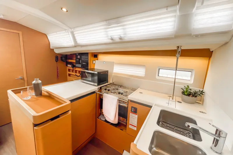 Slide: The Image of Modern kitchen interior of 2023 Jeanneau Sun Odyssey 440 yacht, featuring sleek design and amenities. - 19