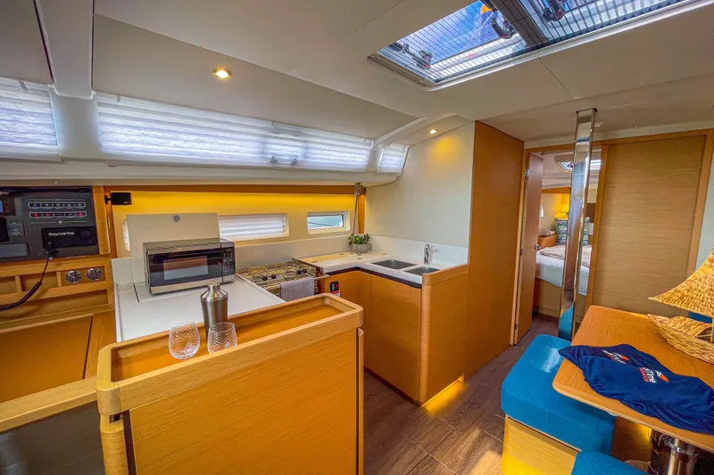 Slide: The Image of Modern interior of 2023 Jeanneau Sun Odyssey 440 yacht with kitchen and seating area. - 16