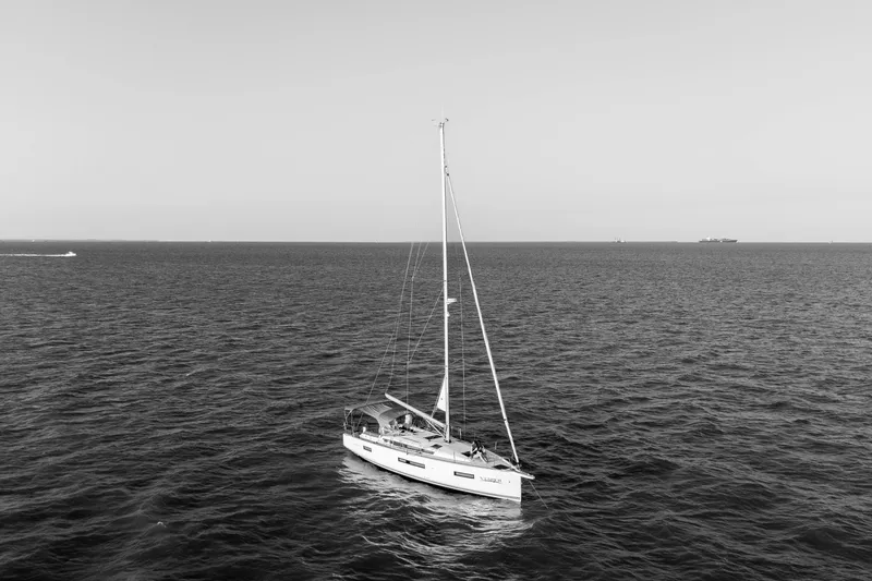 Slide: The Image of 2023 Jeanneau Sun Odyssey 440 sailboat on open sea, black and white image. - 7