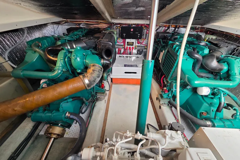 Slide: The Image of Engine room of a 1999 Fortier Express 33 boat, showcasing dual green engines. - 29