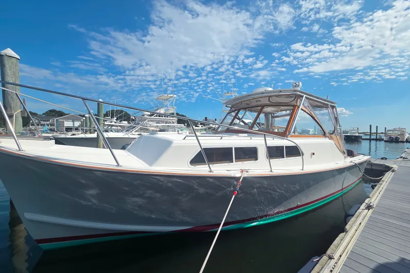 Slide: The Image of 1999 Fortier Express 33 boat docked at marina under clear blue sky. - 34