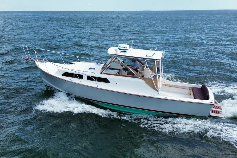 Slide: The Image of 1999 Fortier Express 33 cruising on open water, showcasing sleek design and performance. - 4
