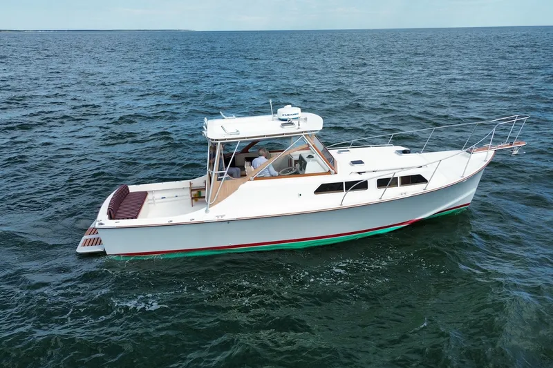 Slide: The Image of 1999 Fortier Express 33 boat cruising on open water. - 3