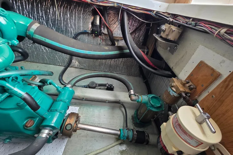 Slide: The Image of Engine compartment of a 1999 Fortier Express 33 boat, showcasing hoses and mechanical components. - 32