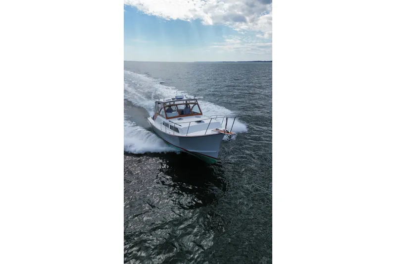 Slide: The Image of 1999 Fortier Express 33 cruising on open water under a partly cloudy sky. - 8