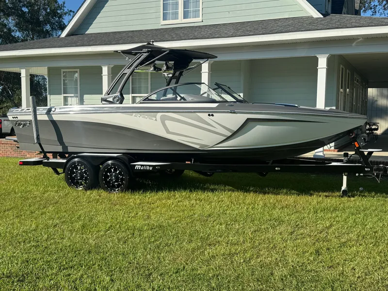 Slide: The Image of Een grijze Tigé R23 boot uit 2018 op een trailer voor een huis. - 3