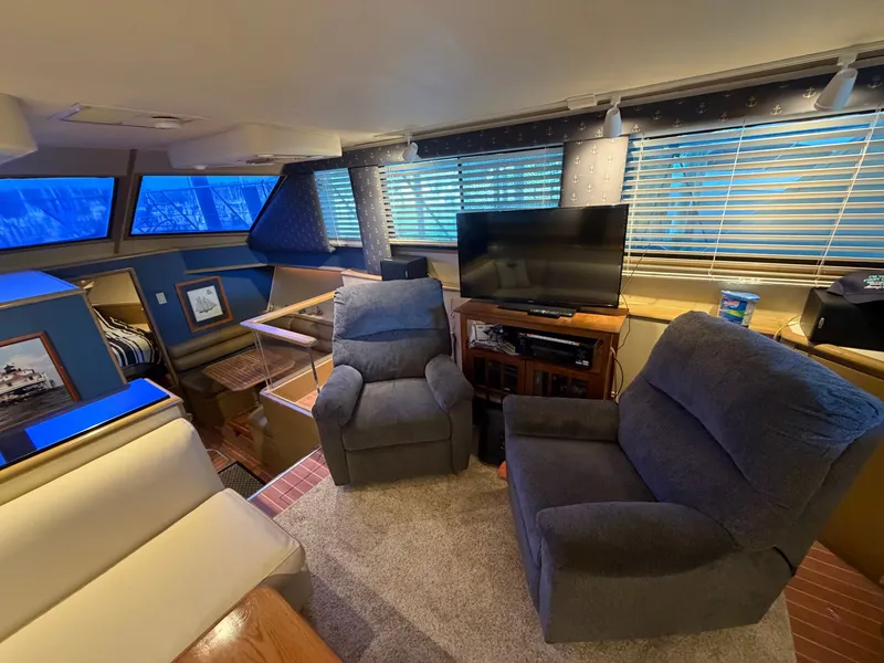 Slide: The Image of Interior of a 1991 Hatteras 52 Cockpit Motor Yacht with cozy armchairs and a television. - 32