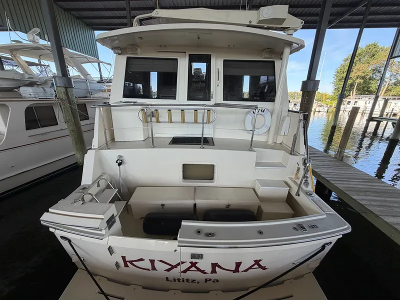 Slide: The Image of A 1991 Hatteras 52 Cockpit Motor Yacht docked under cover. The stern displays the name "KIYANA." - 4