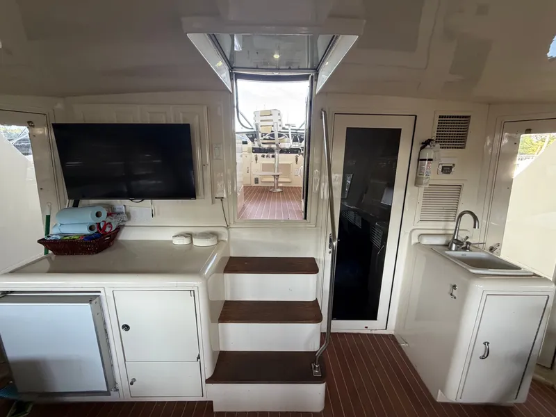 Slide: The Image of Interior of a 1991 Hatteras 52 Cockpit Motor Yacht with stairs, TV, and sink. - 18