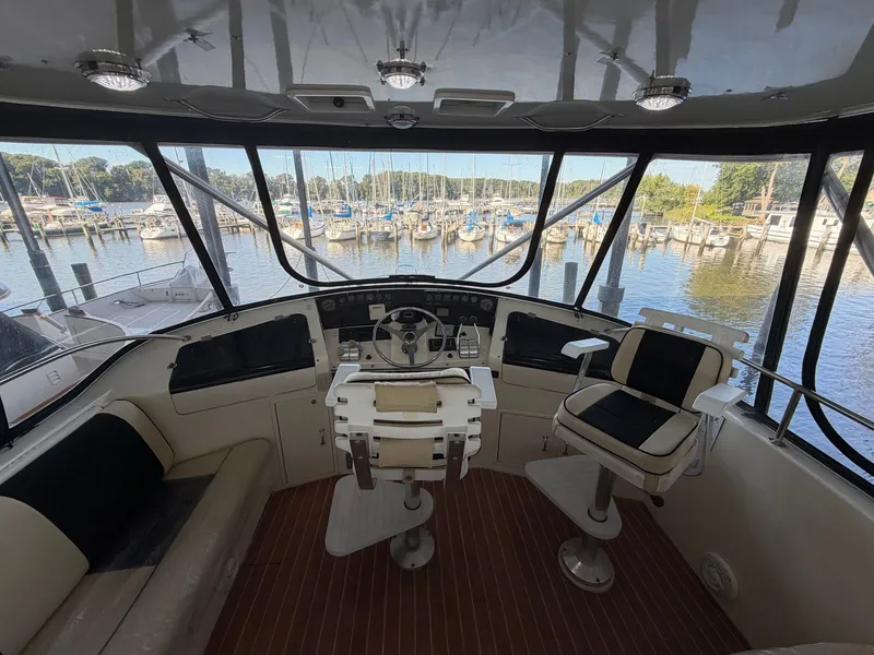 Slide: The Image of The cockpit of a 1991 Hatteras 52 Cockpit Motor Yacht with two seats and a steering wheel. - 19
