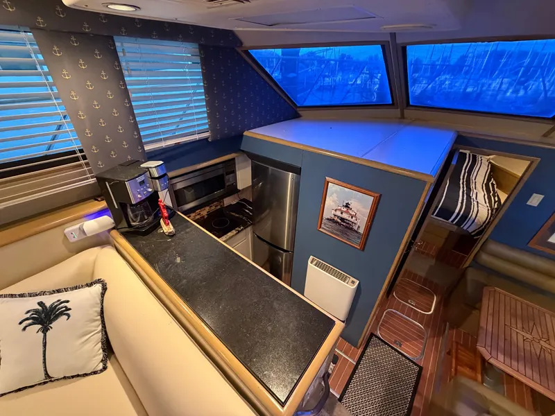 Slide: The Image of Interior of a 1991 Hatteras 52 Cockpit Motor Yacht with a kitchen and cozy living area. - 36